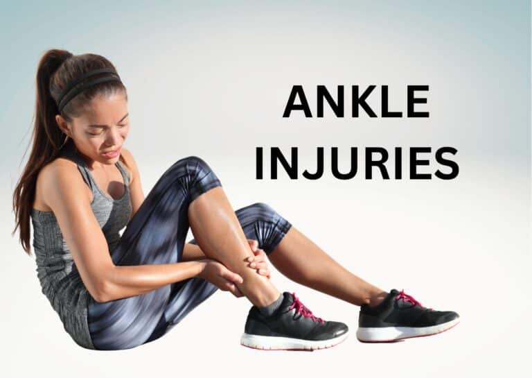 A woman holds her ankle in pain, sitting on the ground, wearing athletic clothing in a light background.